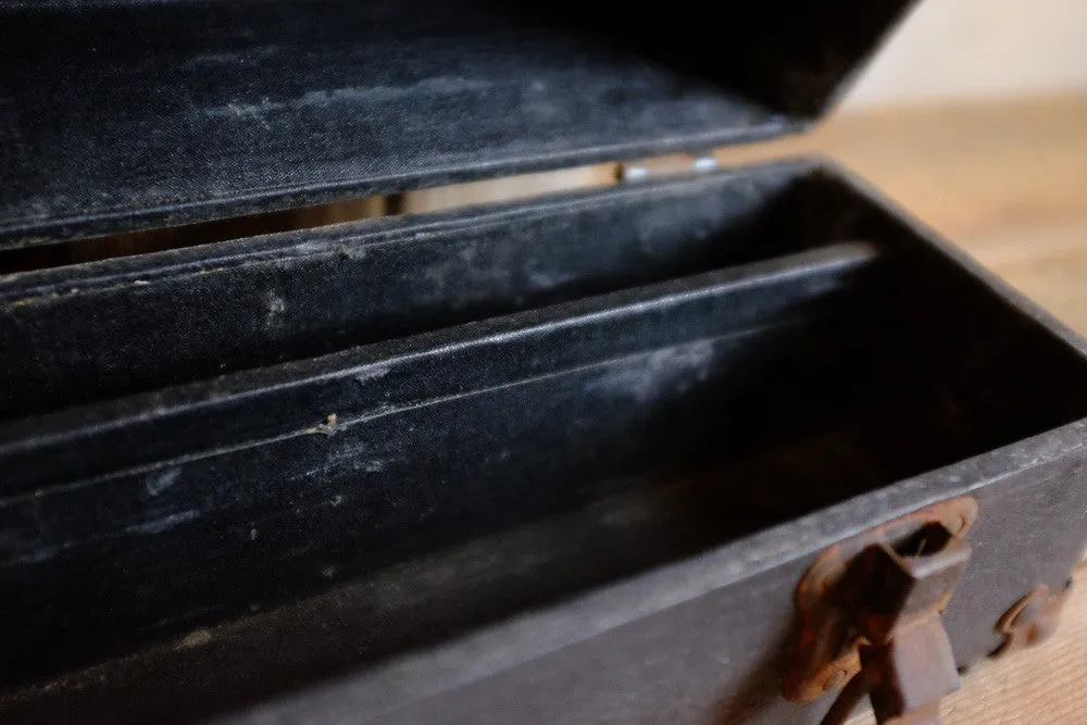 Alexander's rusty black suitcase